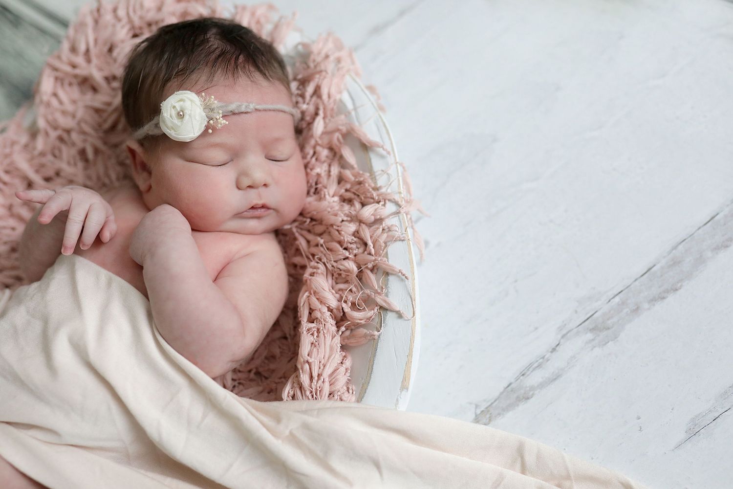Peaceful newborn photography session on white marble backdrop with soft pink accents. Newborn photographer Cleveland, Ohio.