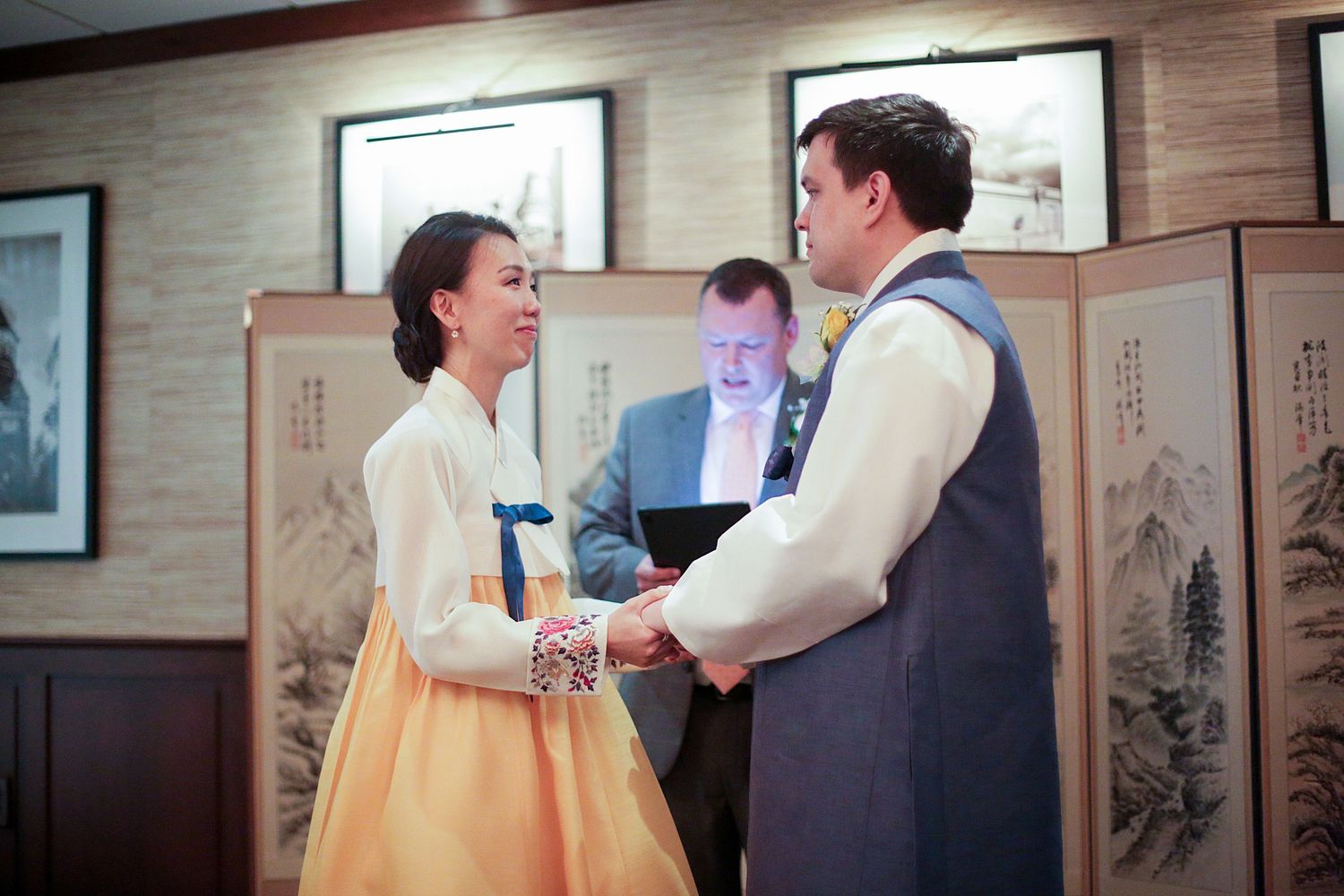 People in traditional Korean hanbok clothing interact during what appears to be a traditional ceremony or celebration.