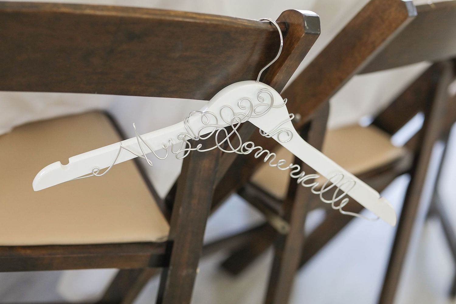 A close up view of gray upholstered dining chairs with detailed curves and spindles highlighting their elegant design.