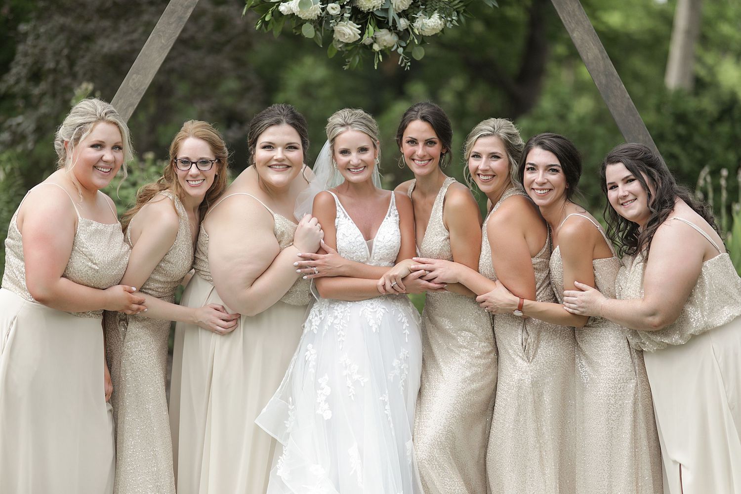 Bridal party in neutral champagne dresses poses together outdoors. Wedding Photographer in Cleveland Ohio