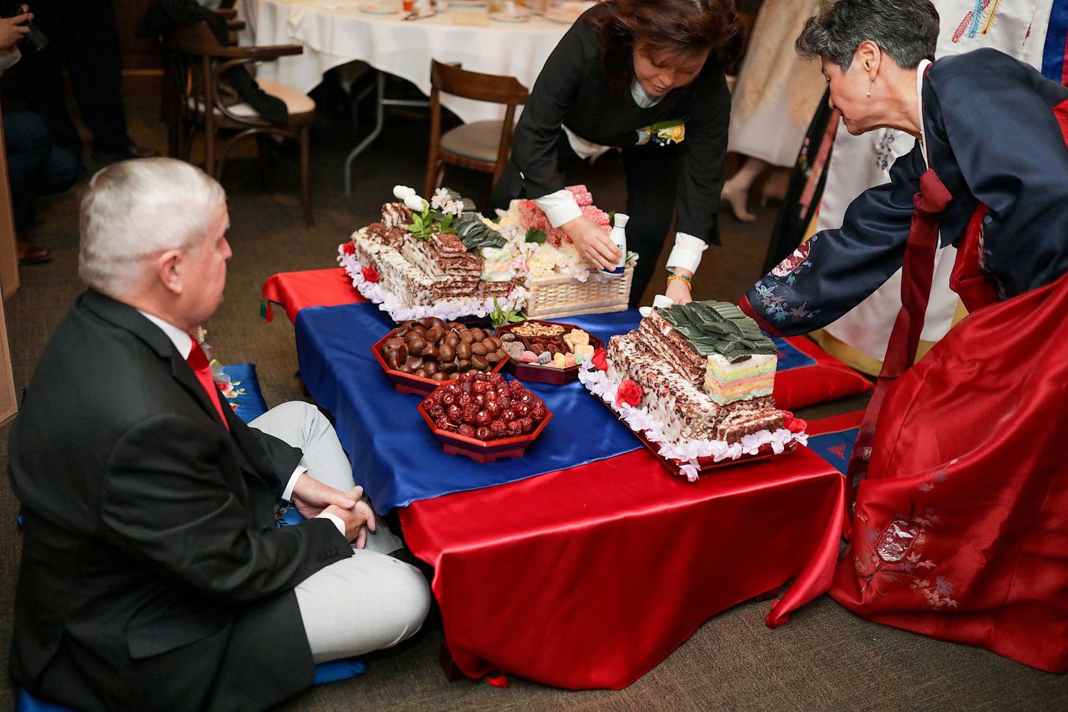 A buffet table displays a variety of decorated red and white holiday desserts and pastries.