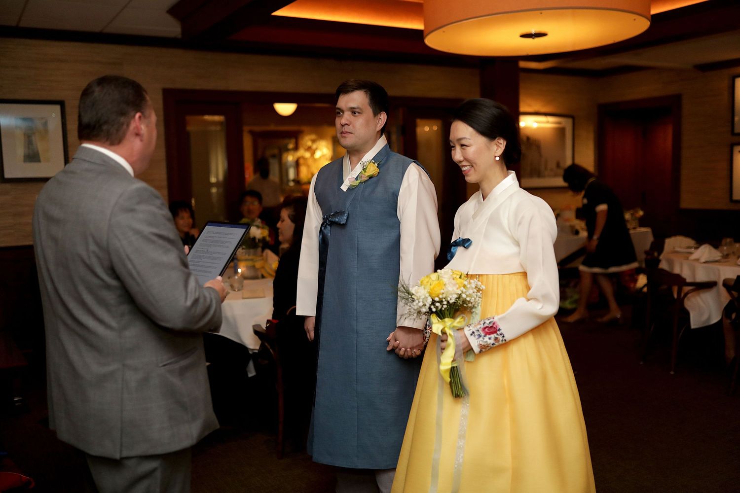 A group gathers at a formal event in an indoor venue with warm lighting and elegant decor.