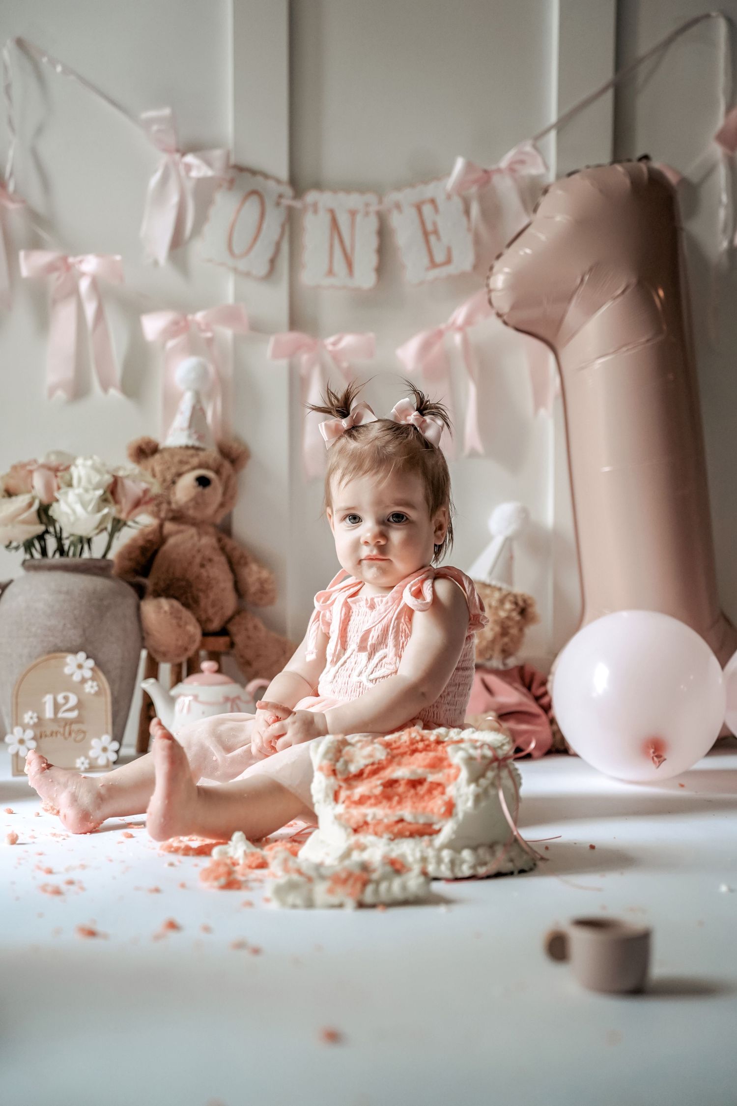 A series of cake smash photos showing progression of birthday celebration with pink decorations and stuffed animals.