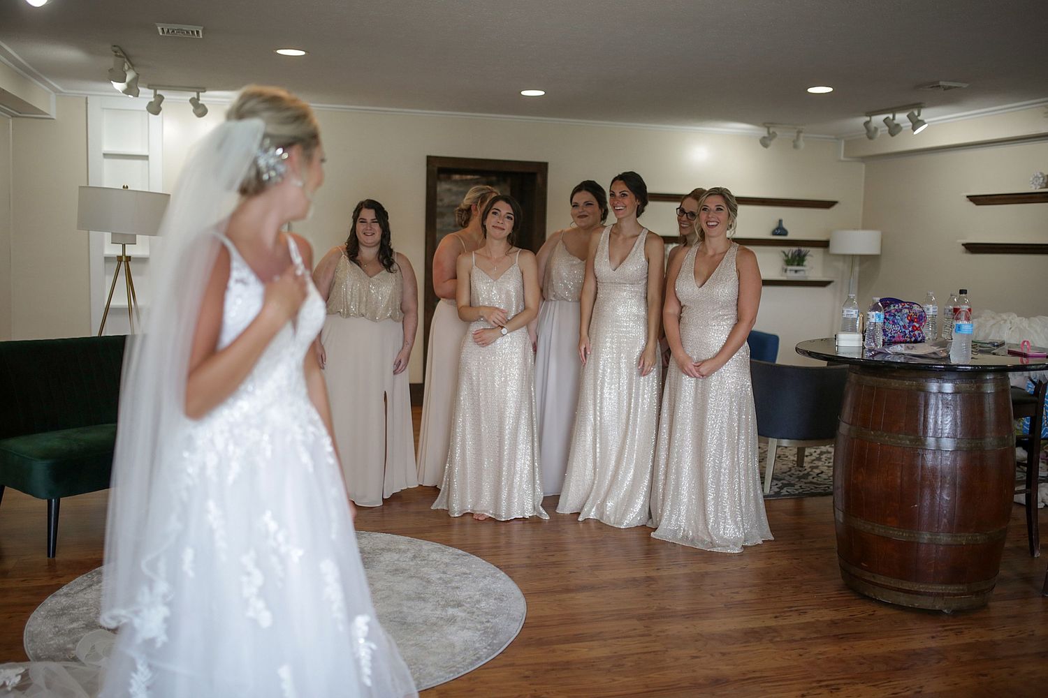 Wedding party preparations in brightly lit dressing room with mirrors.