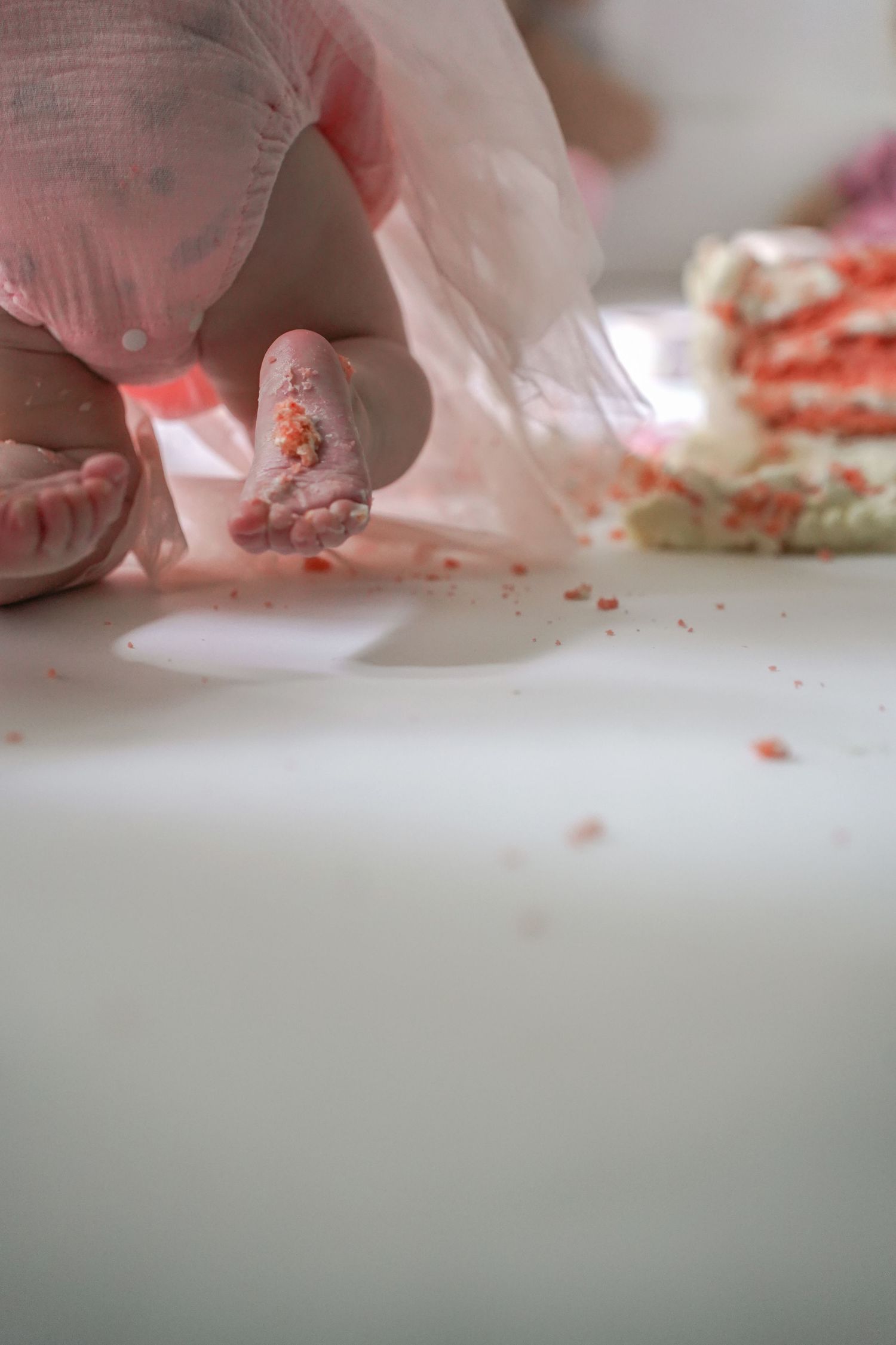 Close-up shot of fingers delicately chopping or dicing ingredients on a white cutting board in a kitchen environment.