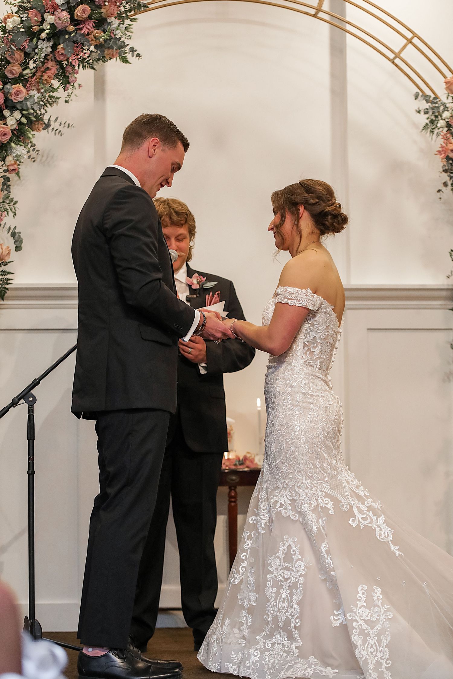 A romantic wedding ceremony sequence showing a bride and groom exchanging rings under a floral arch.