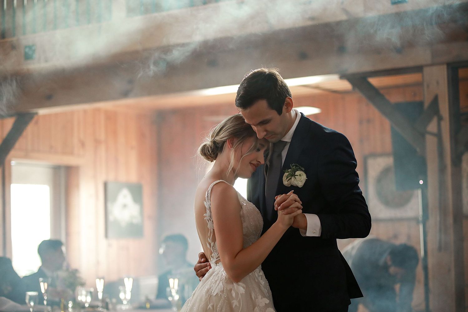 A romantic wedding dance moment captured with atmospheric smoke effects in a rustic venue. Wedding Photographer in Cleveland Ohio