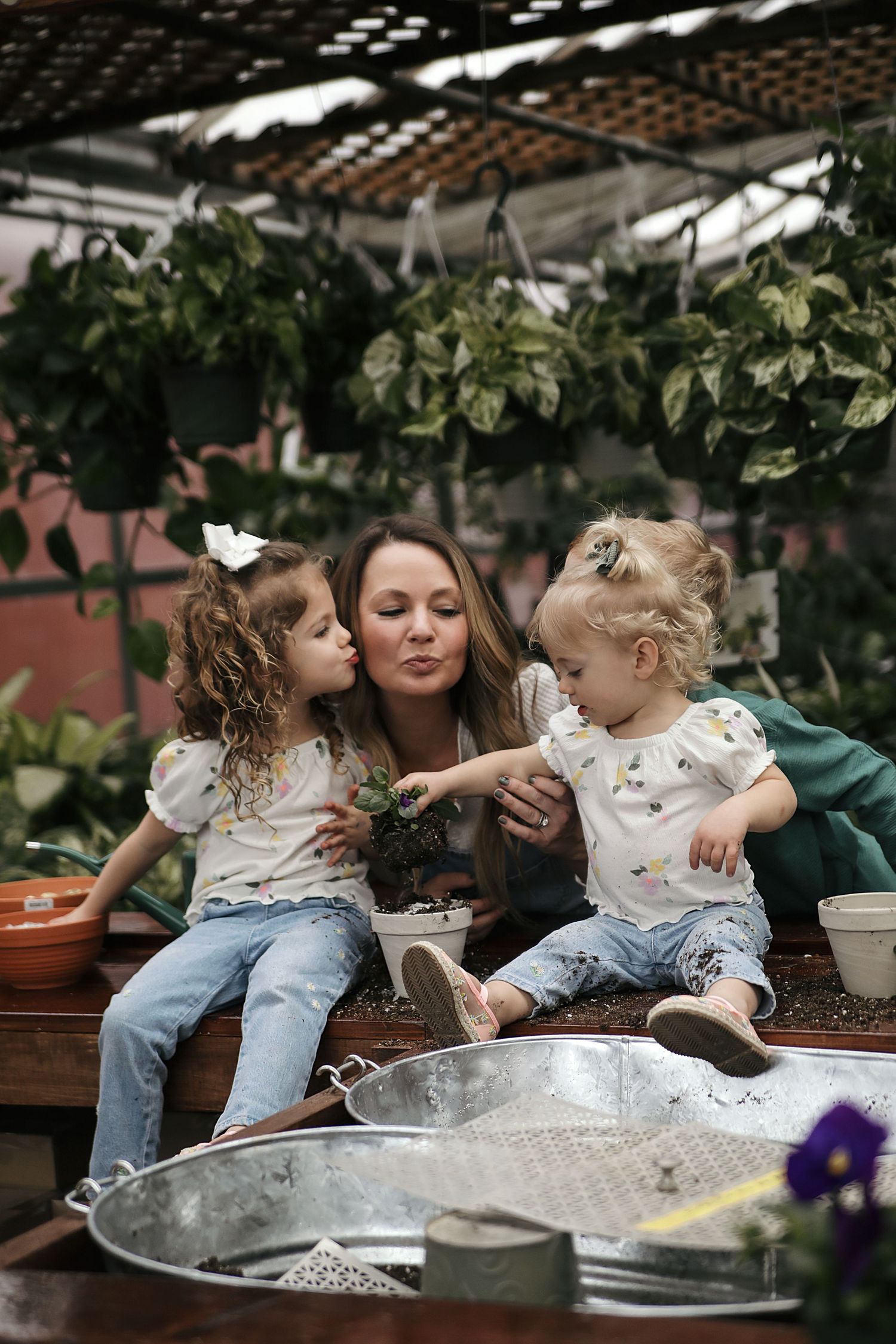 Group enjoys a sweet outdoor tea party with laughter and moments of affection in a garden setting.