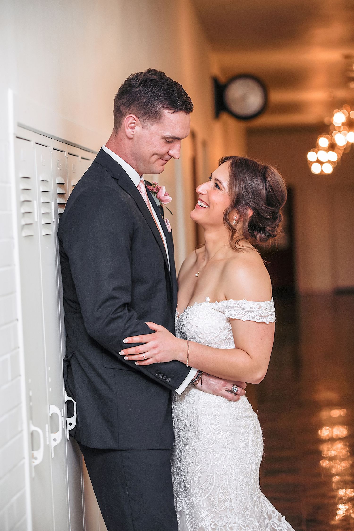 A romantic wedding couple shares intimate moments in a series of black and white portraits against a white wall.