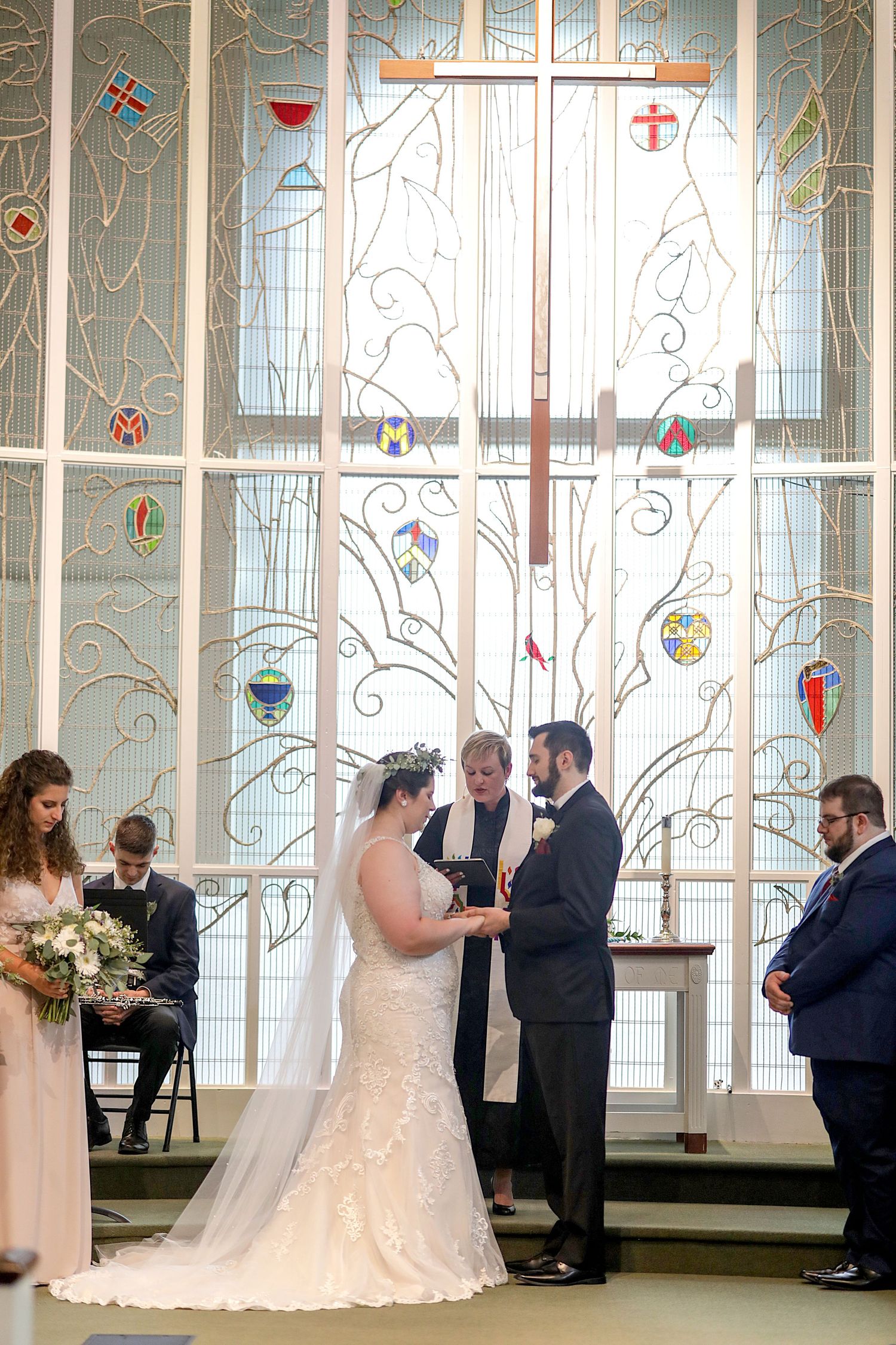 A wedding ceremony progression shown in multiple frames inside an elegant chapel with stained glass windows and white columns.