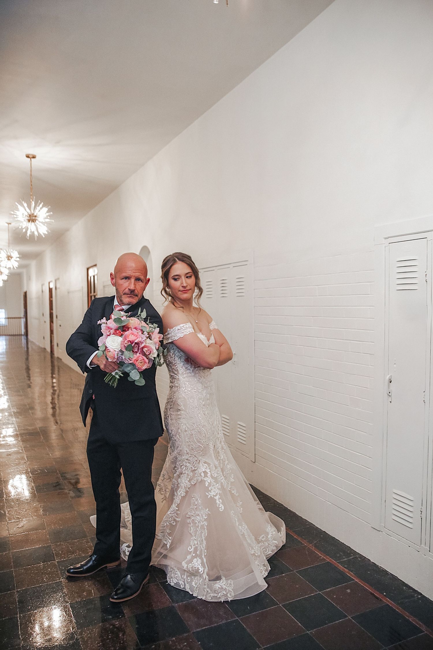 Three candid photos show a couple sharing a joyful moment in a white-walled hallway during their wedding celebration.
