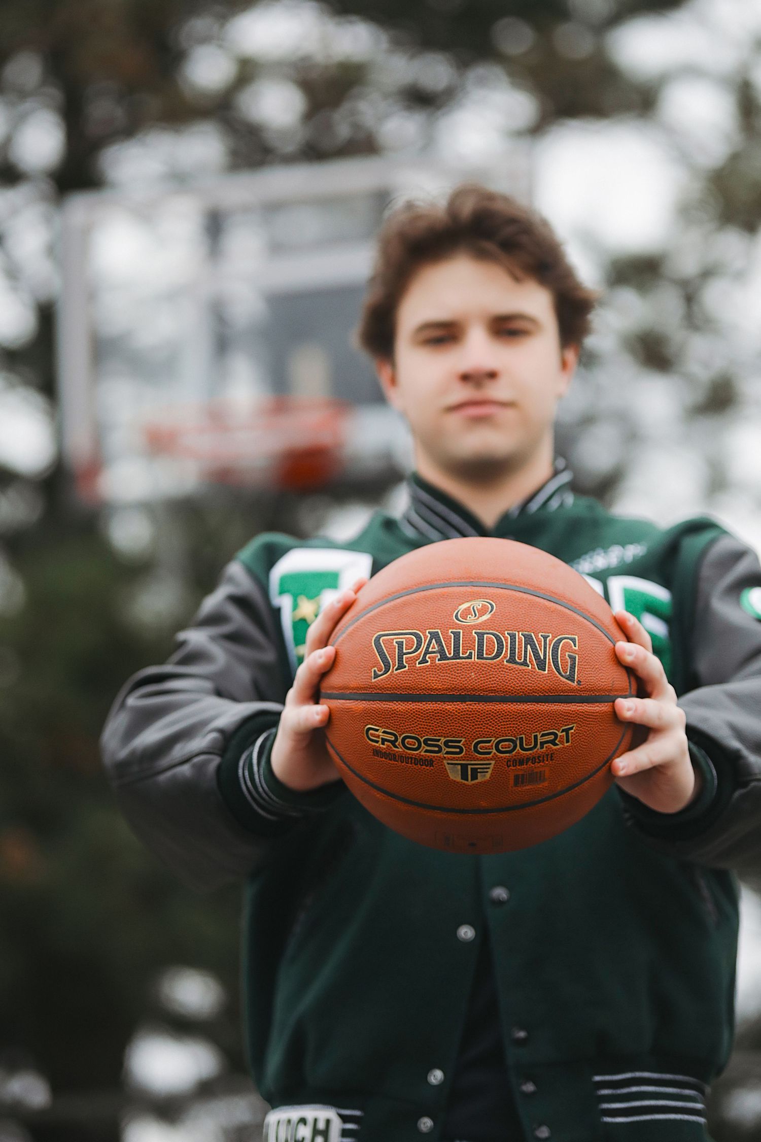 Person in a green jacket holds a Spalding basketball at different angles in a series of cropped photos.
