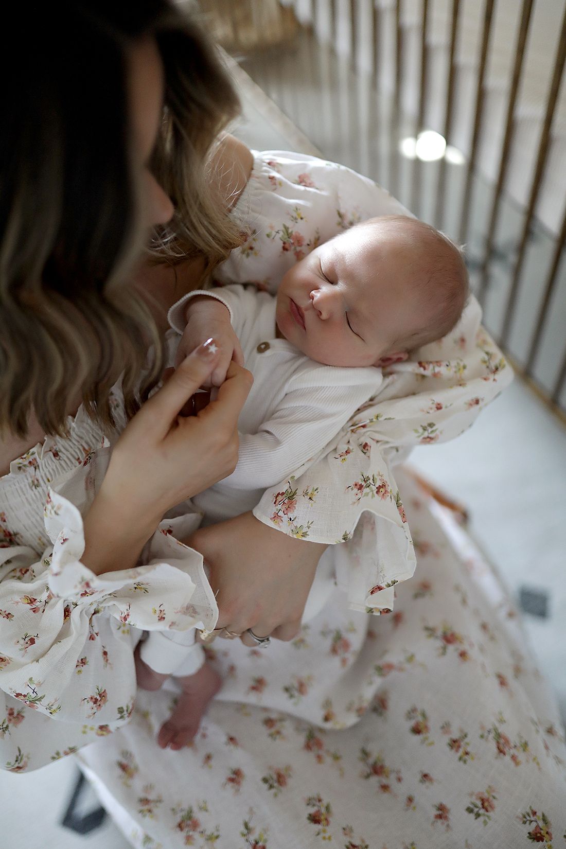 Sweet moment between child and parent in floral dress against white background. Newborn photographer Medina, Ohio.