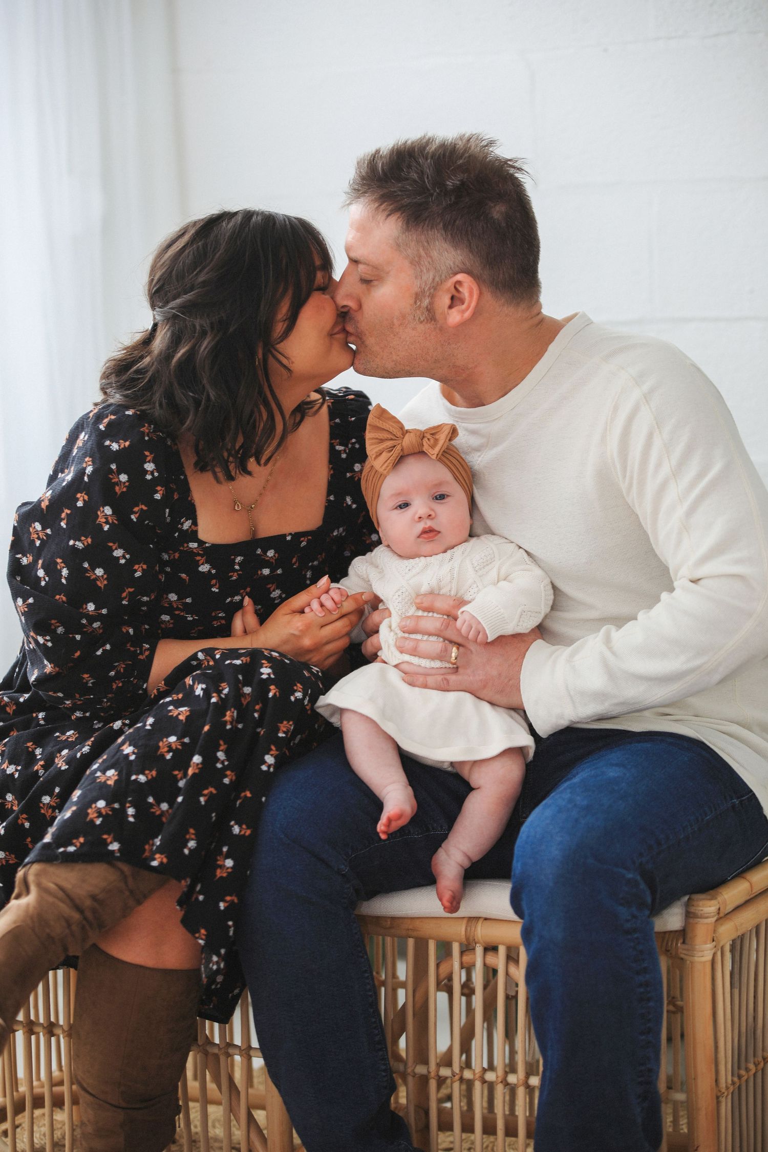 A family shares tender moments while sitting together on a wooden bench in a sequence of candid shots.