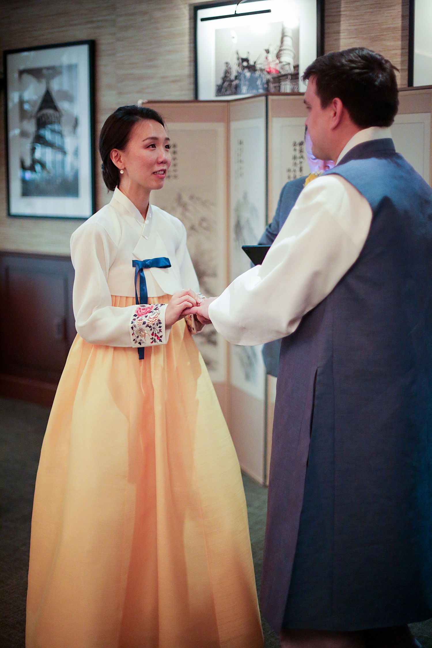 Sequence of images showing traditional Korean hanbok dress in peach and white during a formal indoor celebration.
