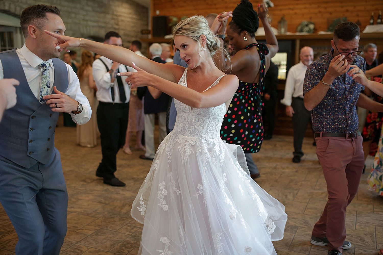 Wedding reception dance floor filled with joyful celebration and movement.