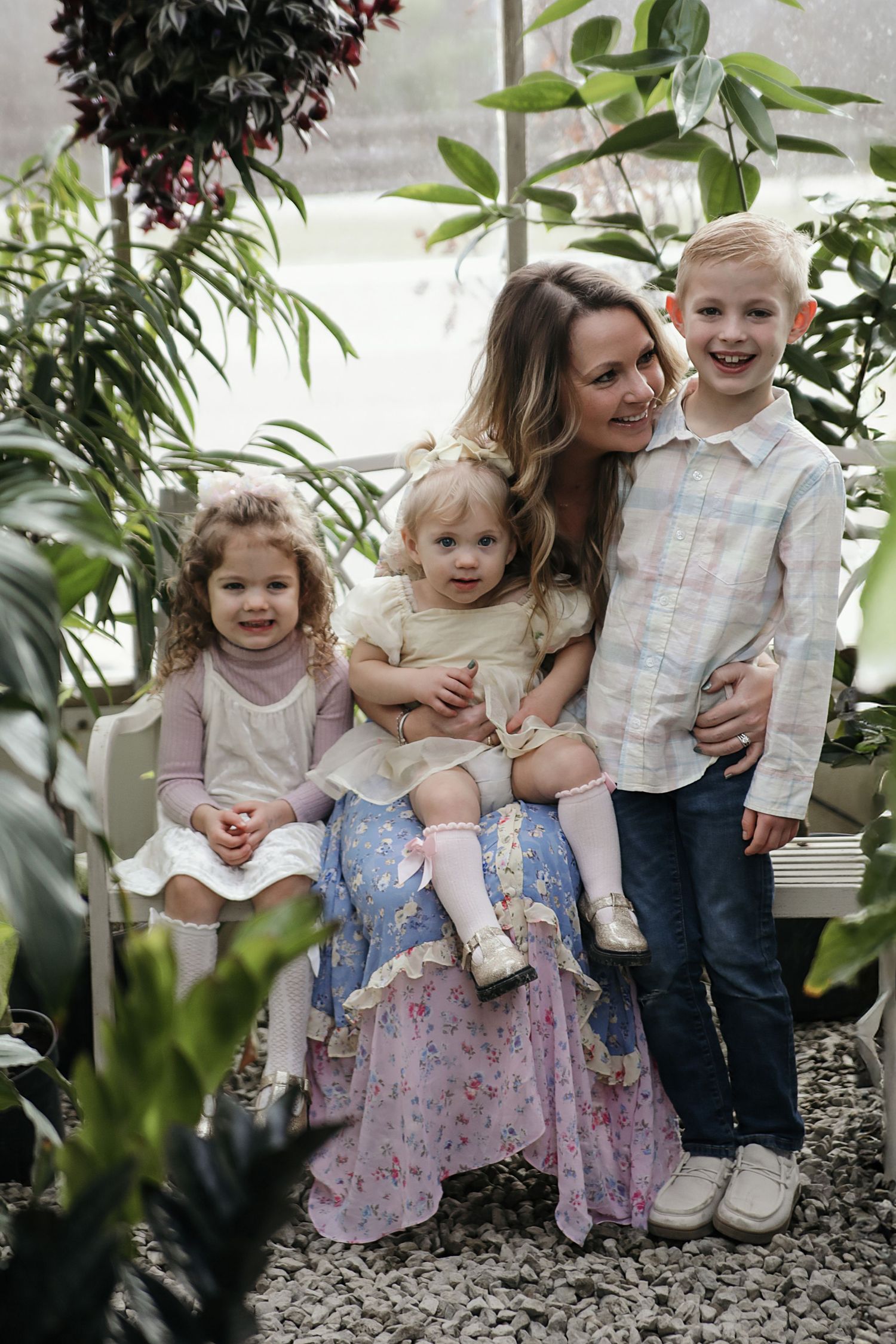 A series of candid greenhouse photos showing casual family moments on a garden pathway surrounded by lush plants.