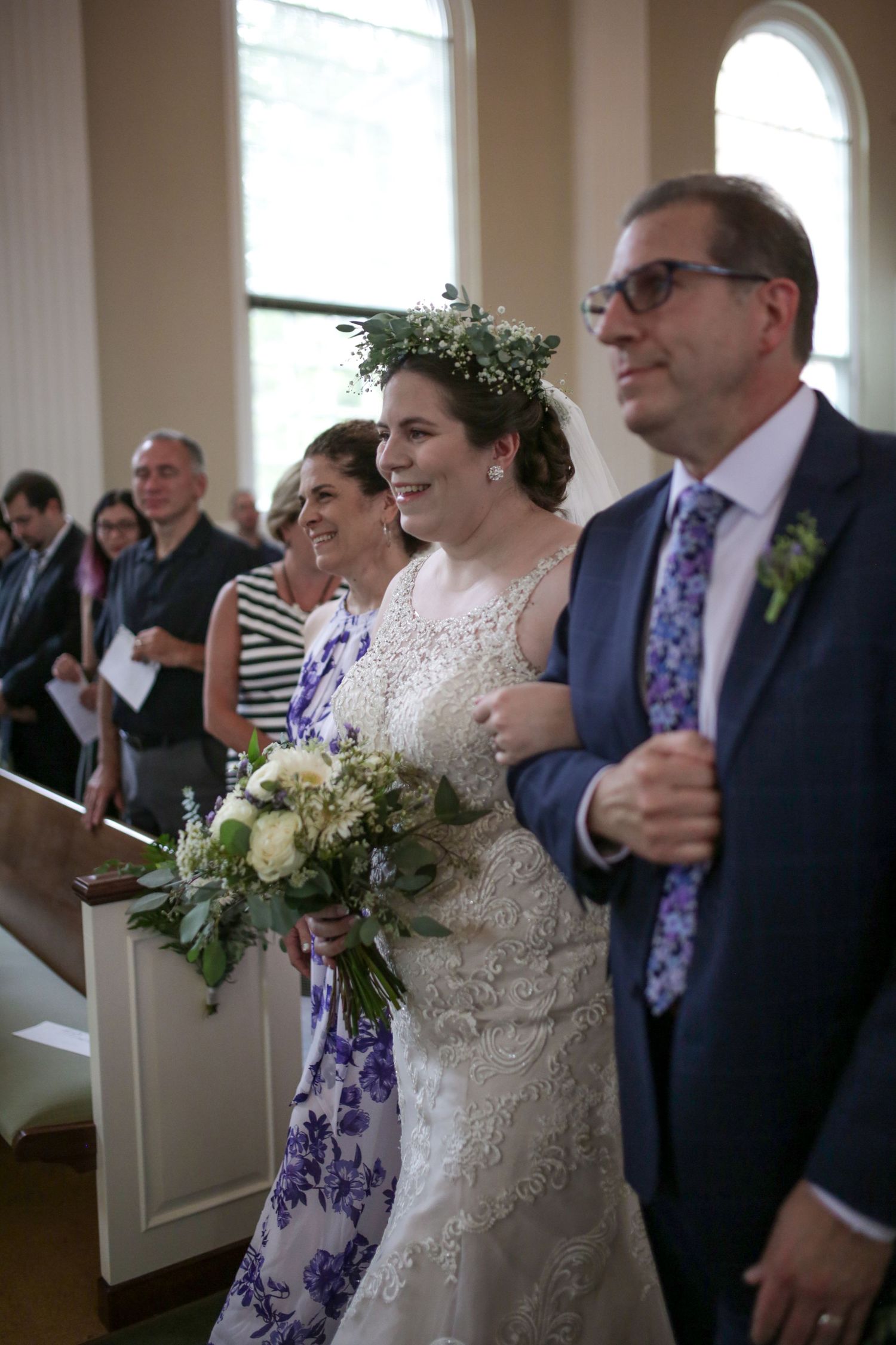 A joyful wedding ceremony moment inside a bright church, with the bride wearing a lace dress and floral crown.