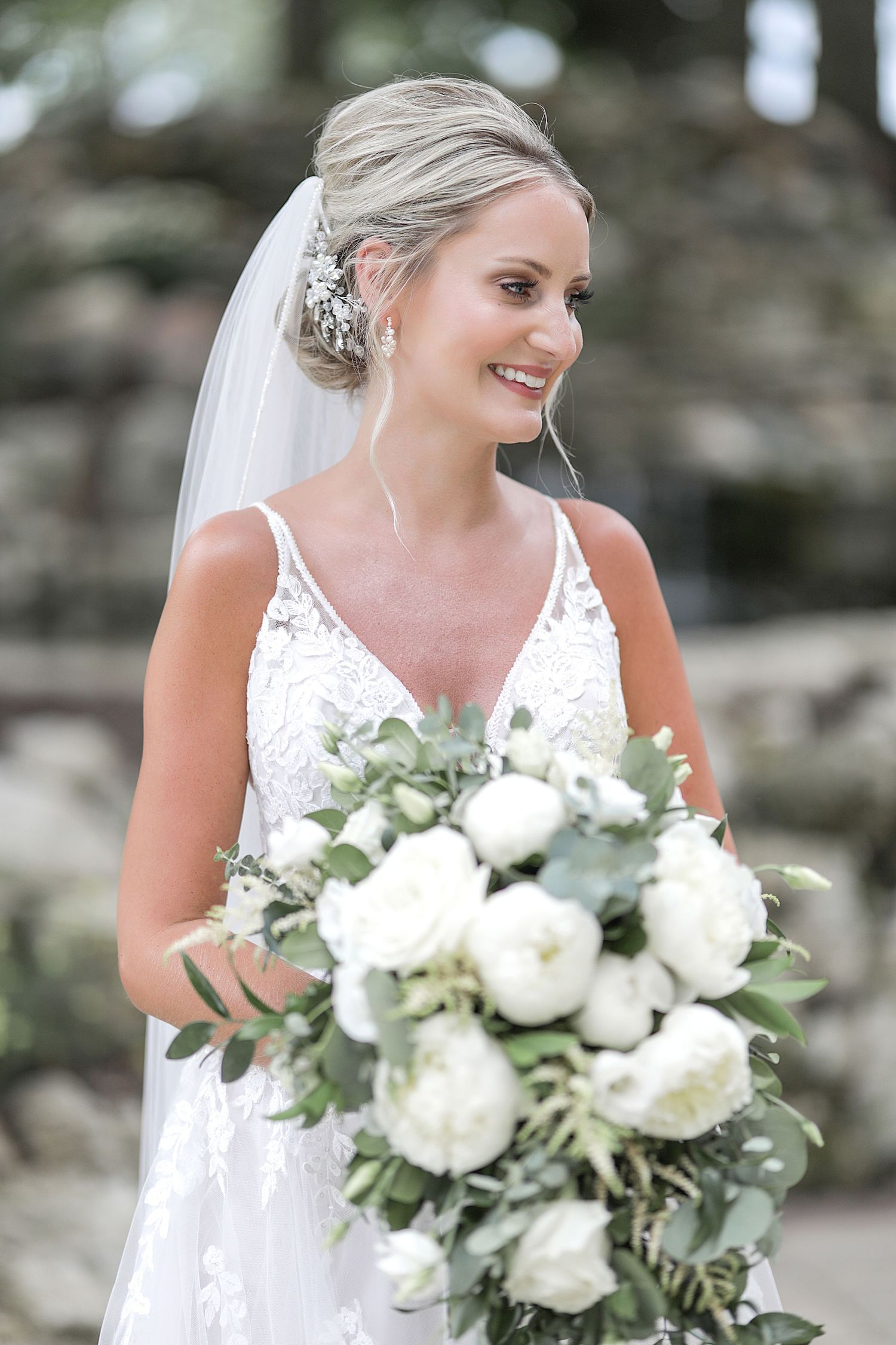 Elegant bridal portrait with white peony bouquet and lace detailed gown.