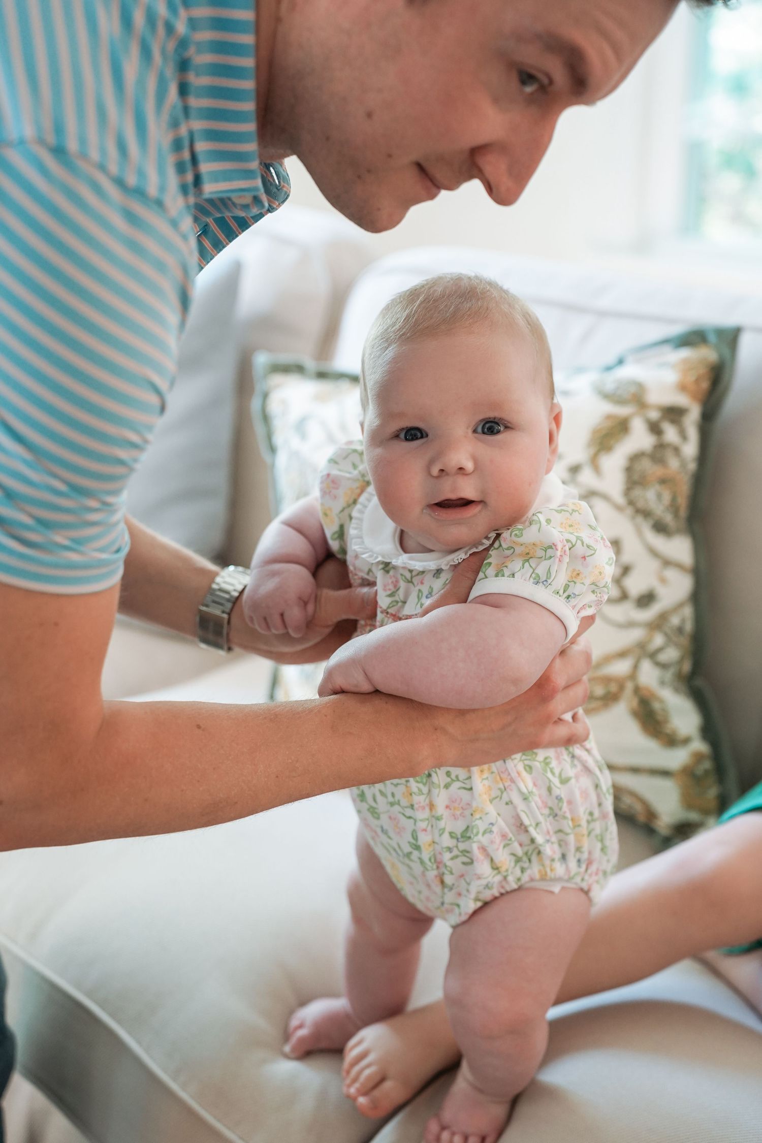 A series of tender moments of parent and baby during a diaper change, captured in natural light.