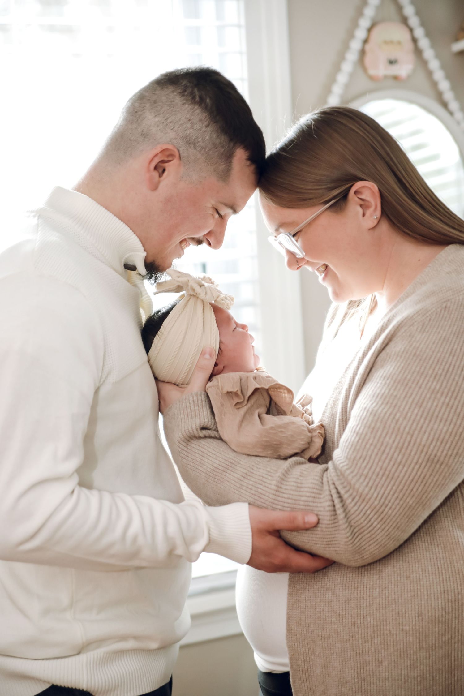 A couple in neutral tones share an intimate moment in a bright, airy space with multiple poses shown.