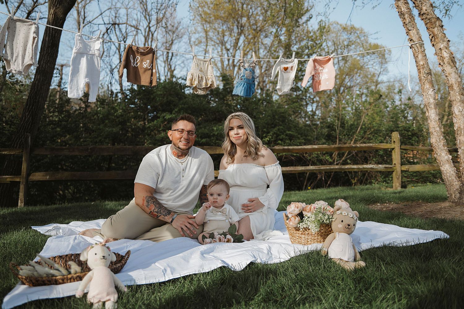 A family enjoys quality time together outdoors on white blankets during a sunny spring day.