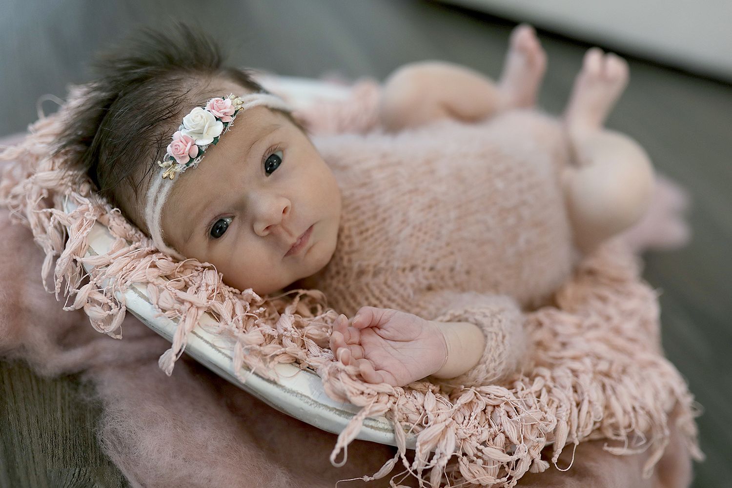 Newborn baby poses on soft pink textured blanket during professional photoshoot. Newborn photographer Cleveland, Ohio.