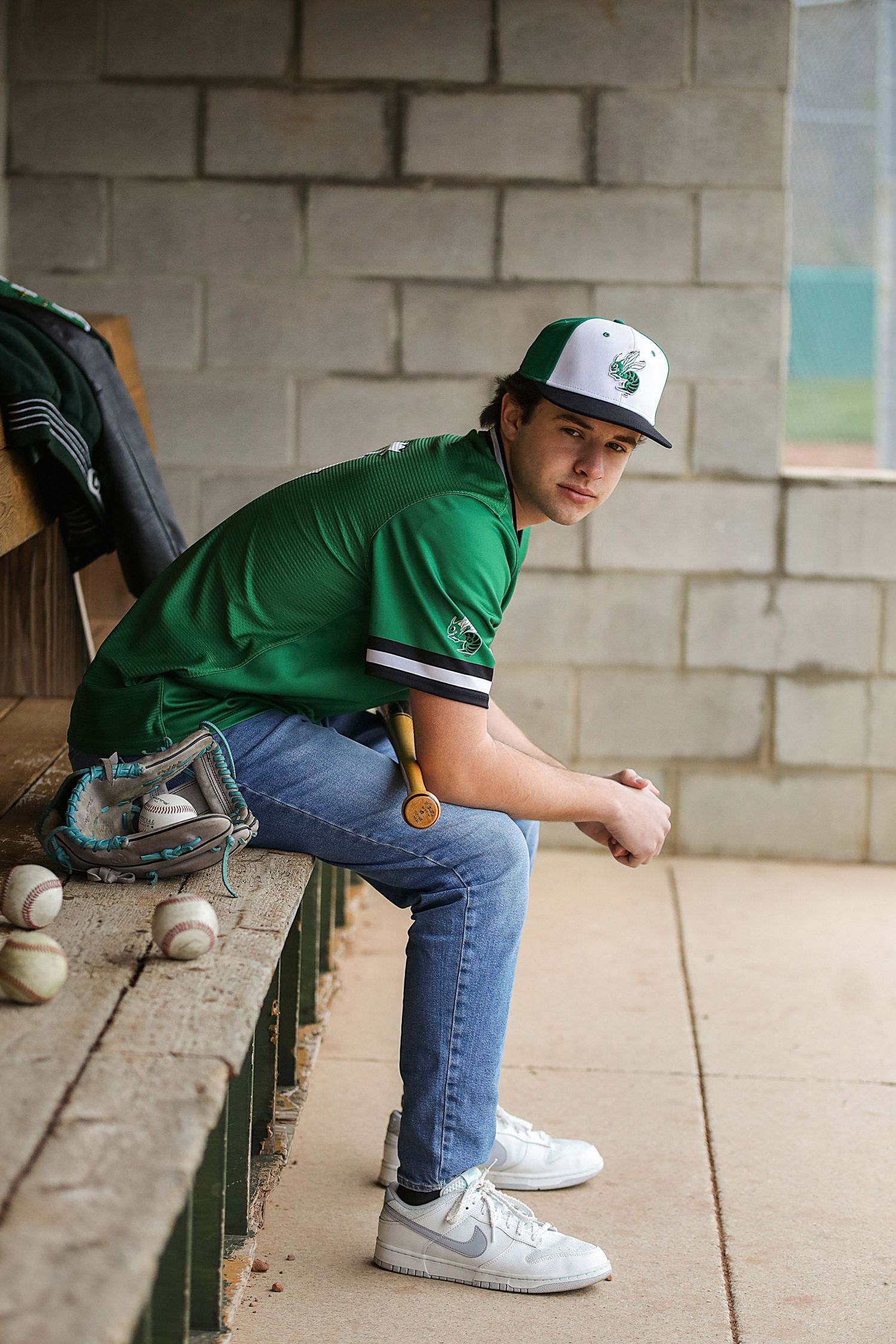Person in green shirt and jeans sits on concrete ledge in four sequential poses showing gradual movement.
