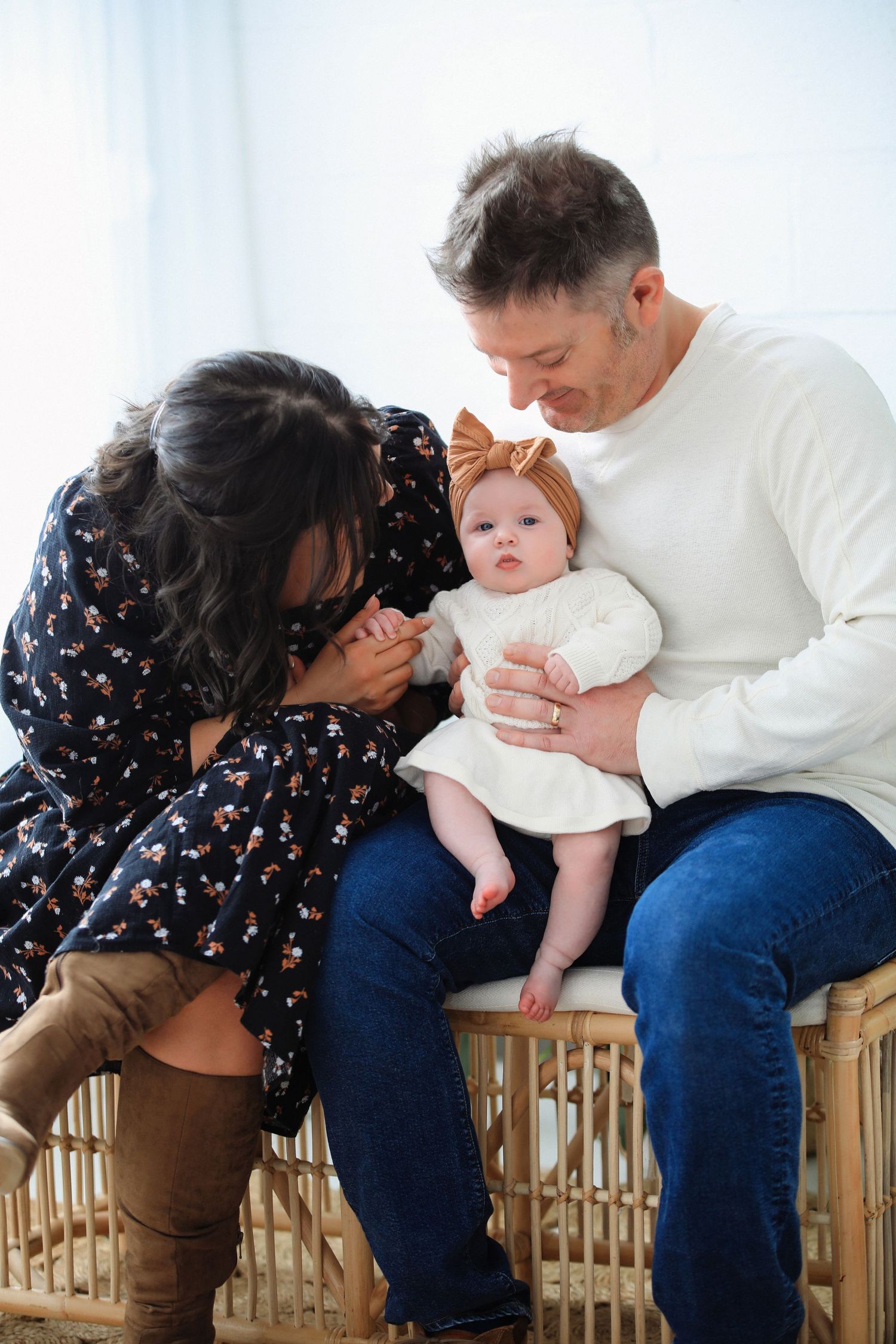 A sequence of photos showing a baby being passed between adults sitting on a wooden bench.