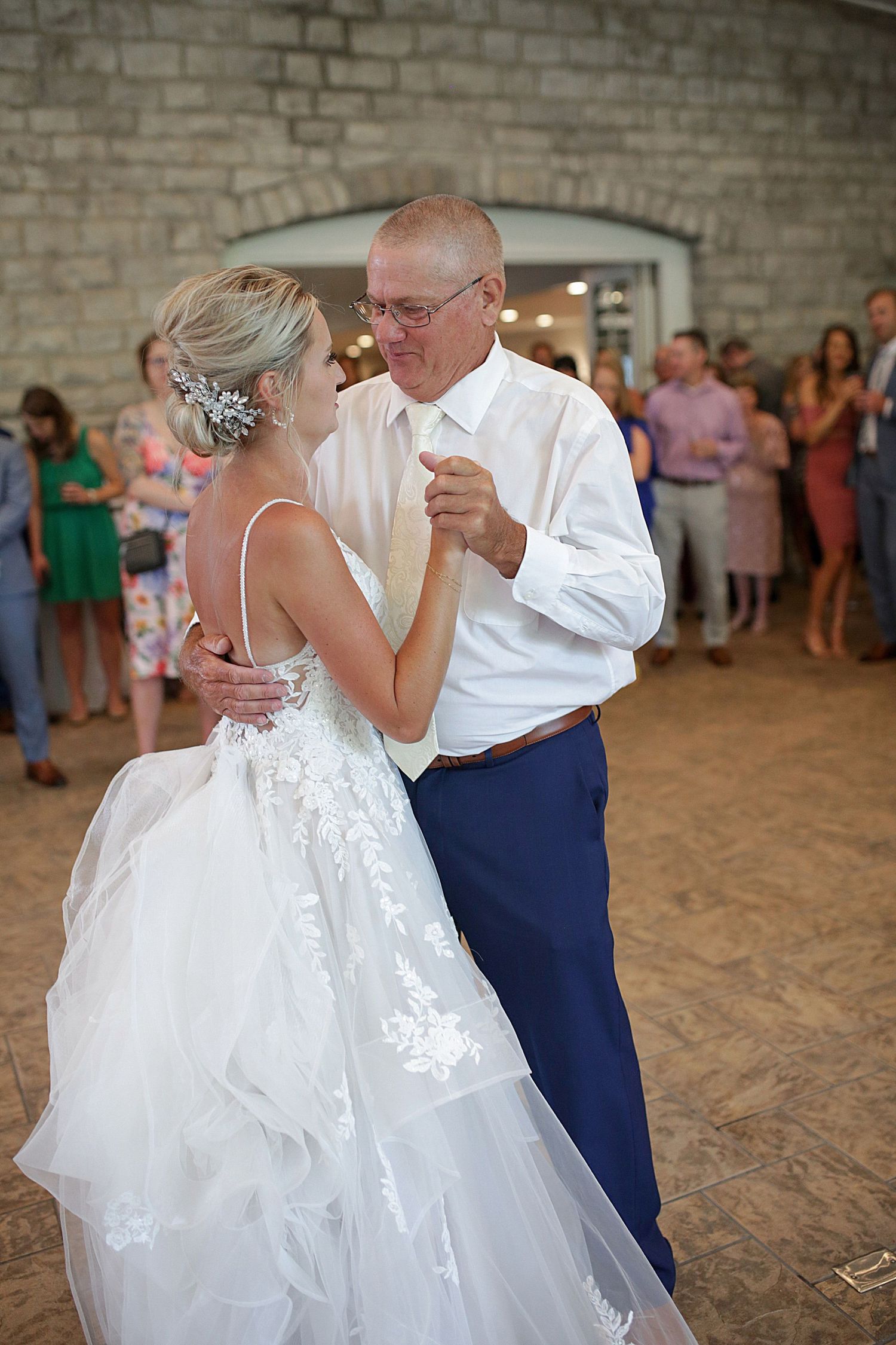 Special dances during wedding reception in rustic brick-walled venue.