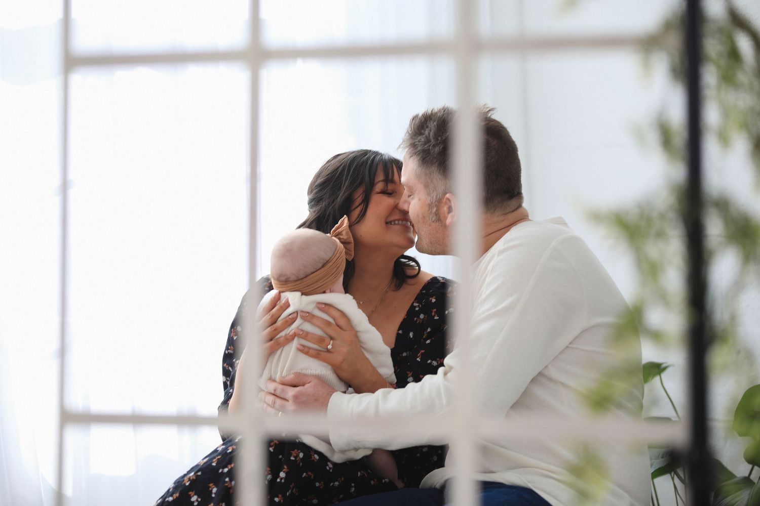 Romantic couple embracing intimately by window in bright natural light.  Family Photography in Medina Ohio.