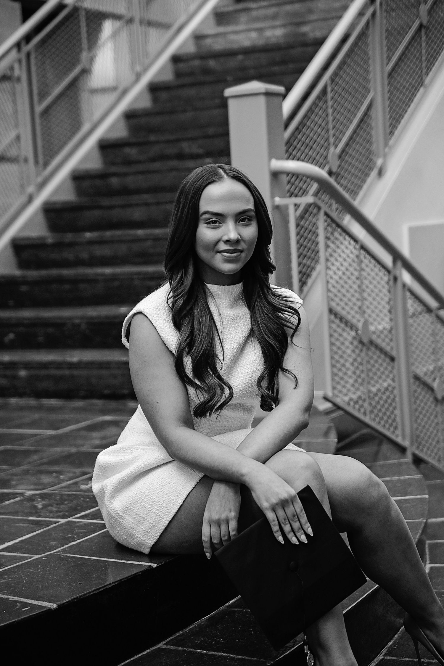 Black and white portrait series showing a person sitting on concrete steps in casual attire.