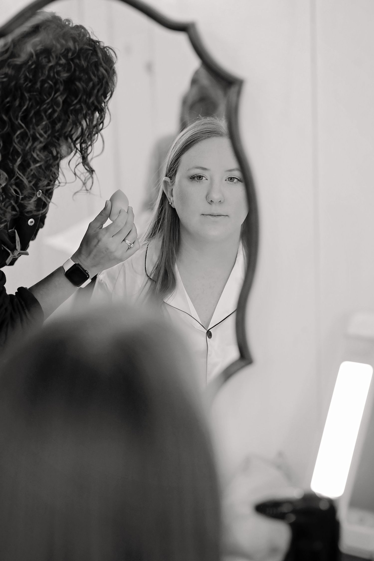 Black and white artistic photo showing delicate preparation moments before a wedding ceremony.