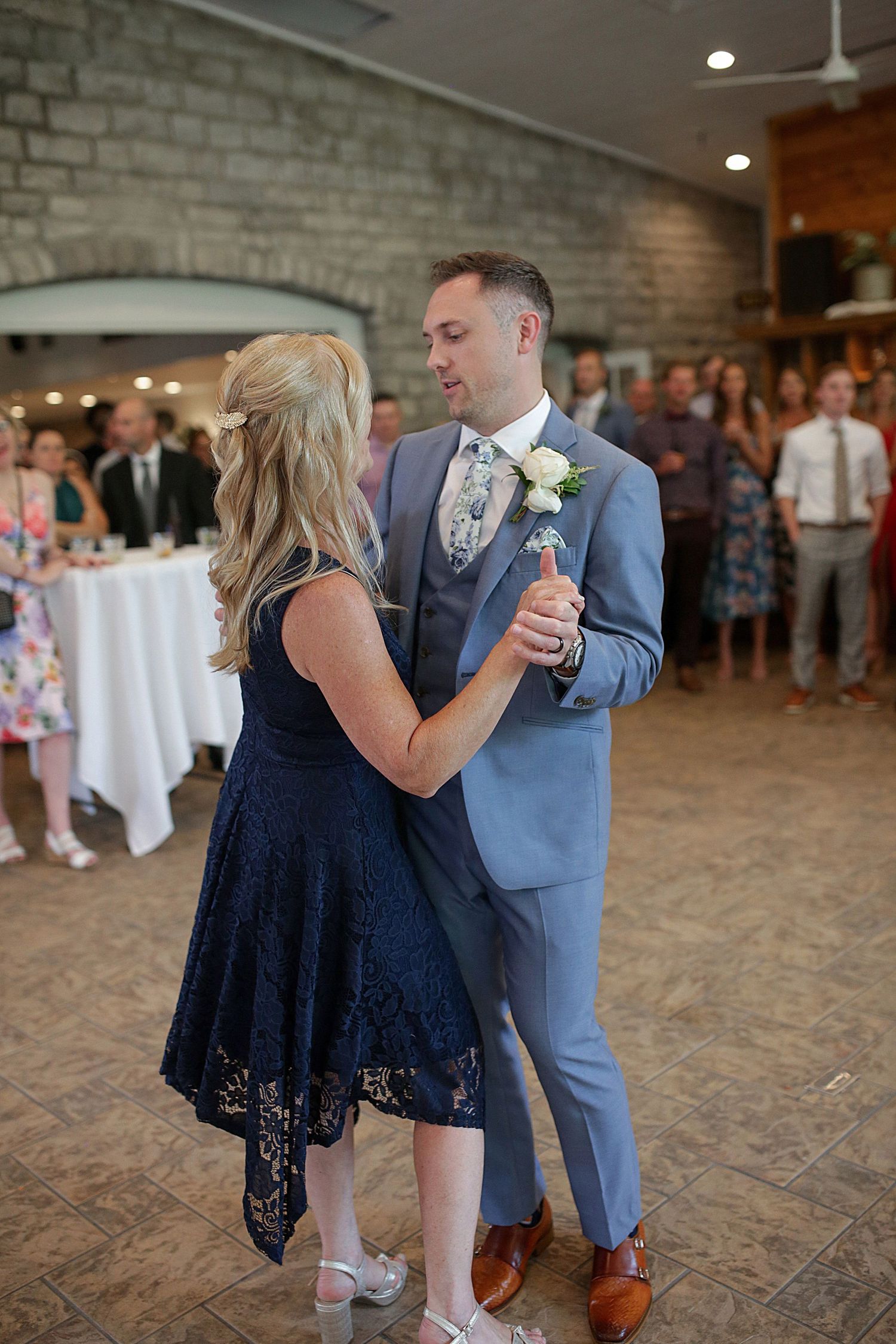 Reception dance sequence in indoor venue with brick walls and wooden floors.