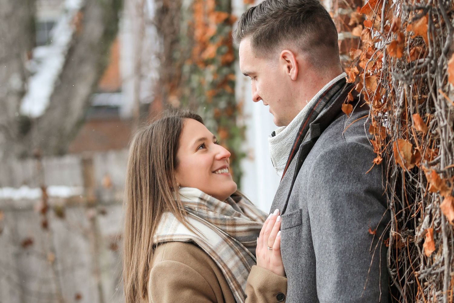 A couple shares an intimate moment together during an autumn photo session in a rustic outdoor setting.