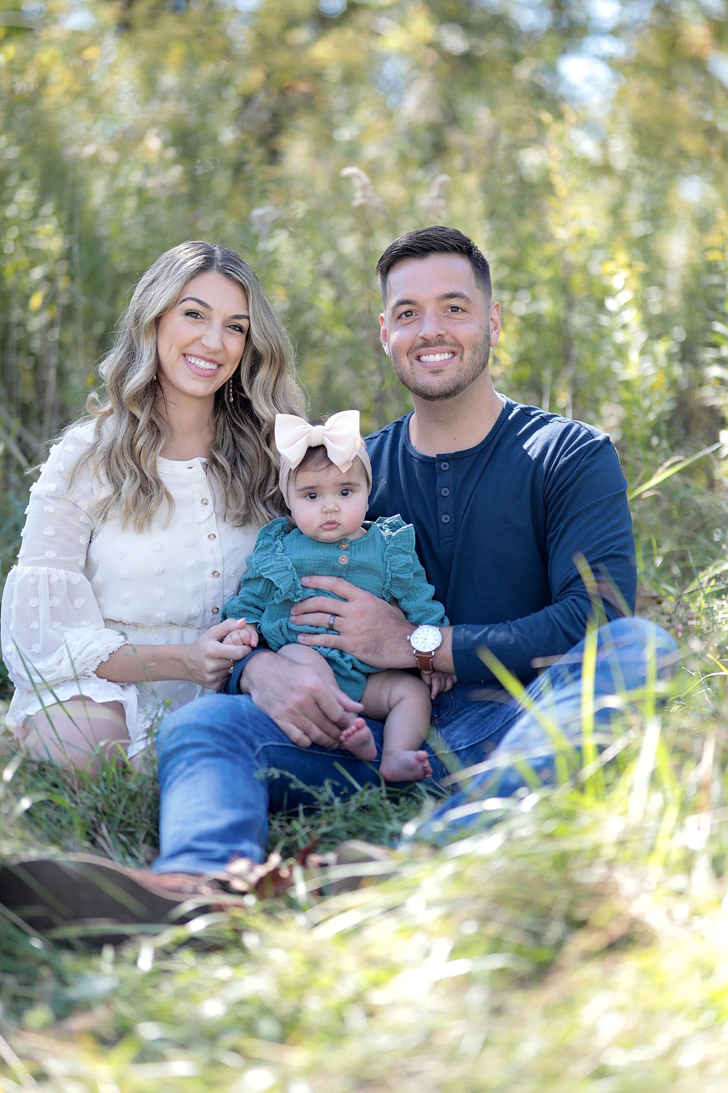 Young family with baby in matching outfits posing for portrait in natural outdoor setting.  Family Photography in Medina Ohio.