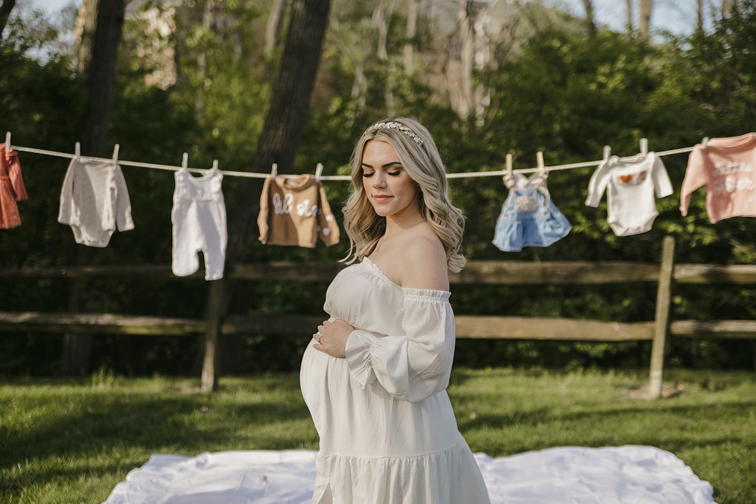 White laundry hangs on clotheslines outdoors against a green garden background during a sunny day.