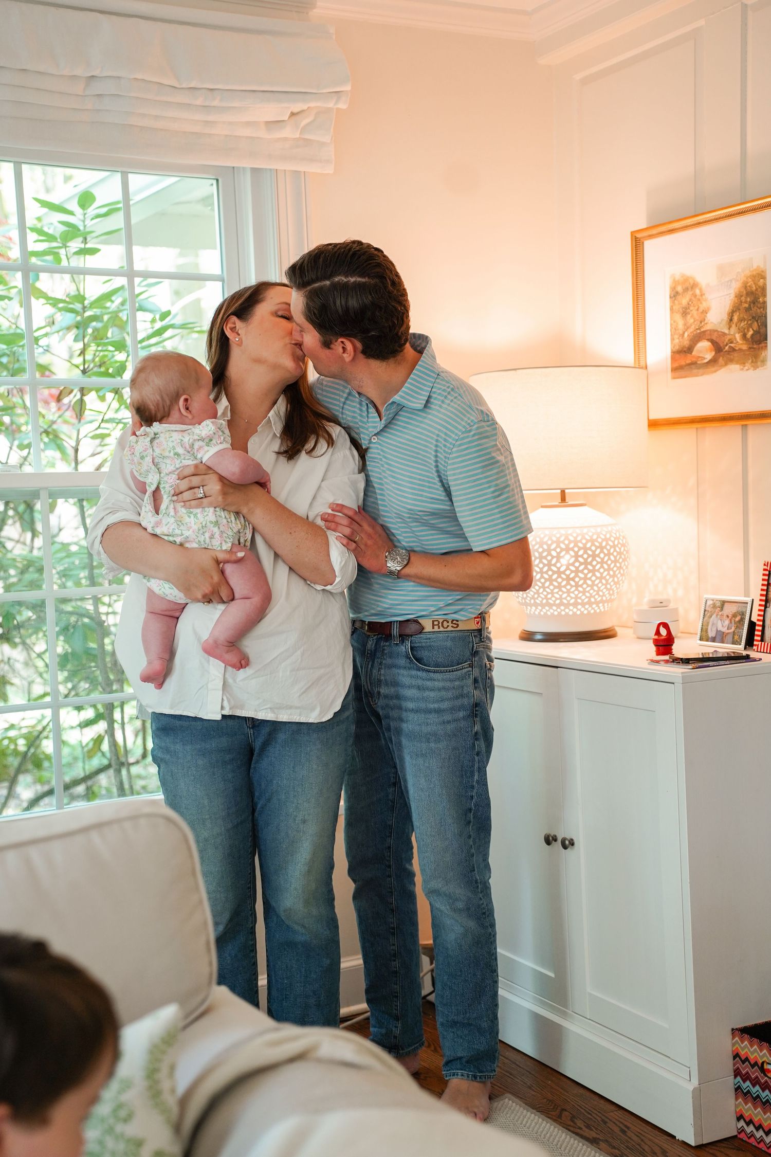 A series of tender family moments in a bright, sunlit living room with white walls and modern decor.
