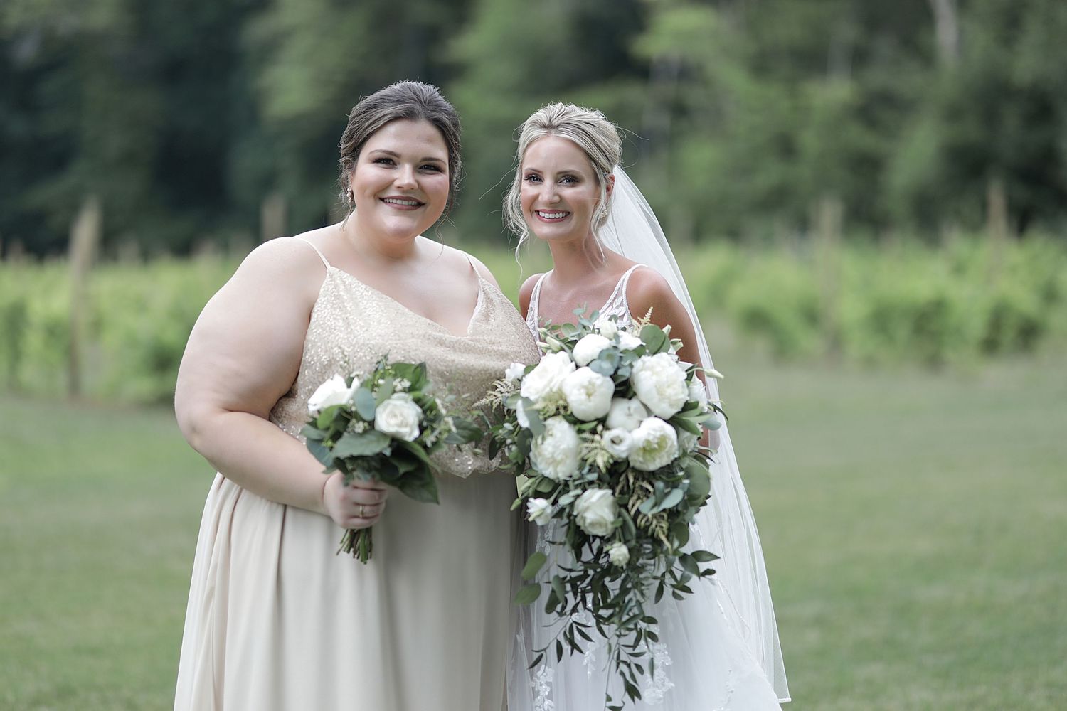 Wedding party posing with bouquets in outdoor garden setting.