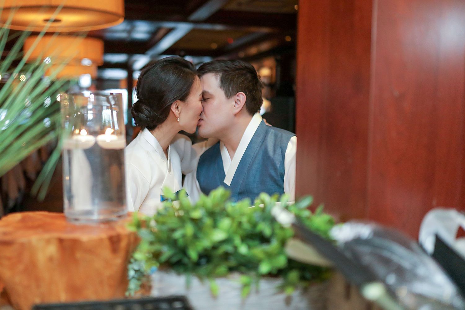 A romantic restaurant scene with lush greenery and warm lighting creates an intimate dining atmosphere.