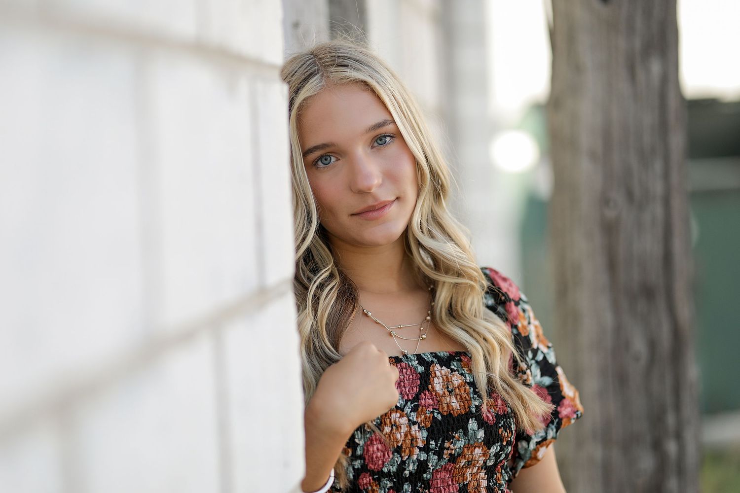 A series of four outdoor portraits showing someone in a floral dress with blonde hair in natural sunlight.