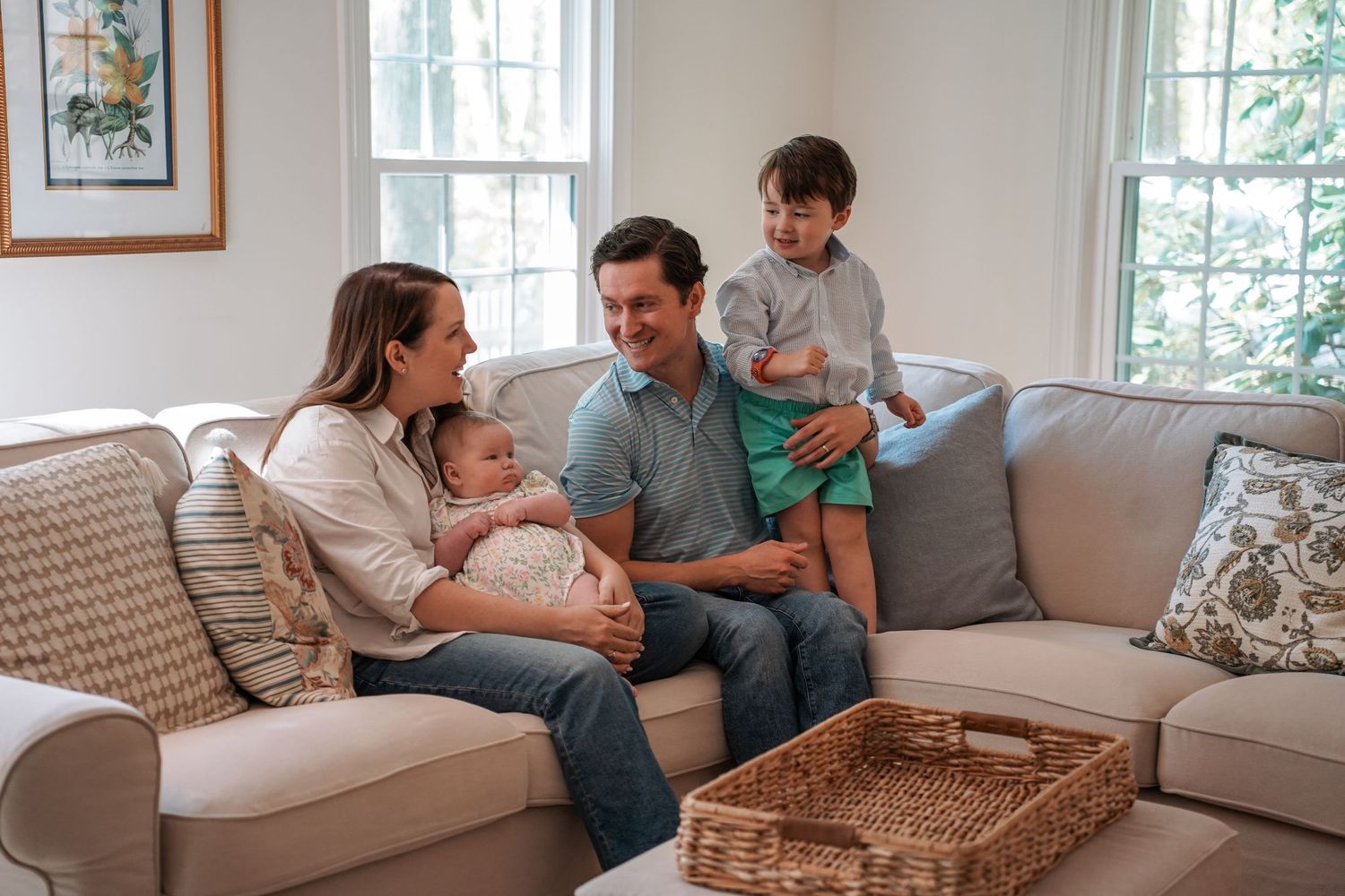A series of photos showing a couple relaxing and snuggling together on a light gray couch in a bright living room.