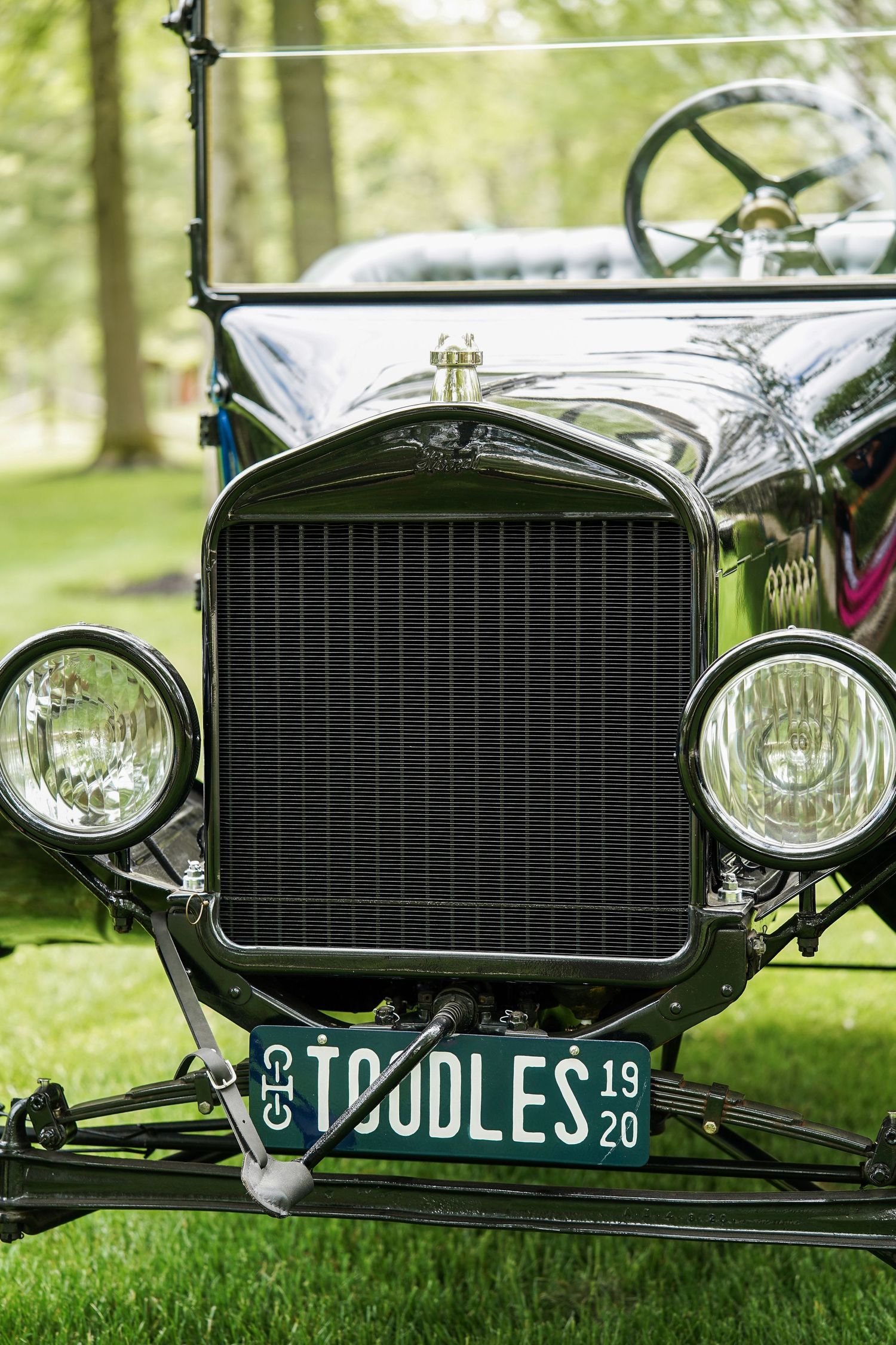 Front view of a vintage Ford Model T with a custom 'T OODLES' license plate and classic black radiator grille and headlights.