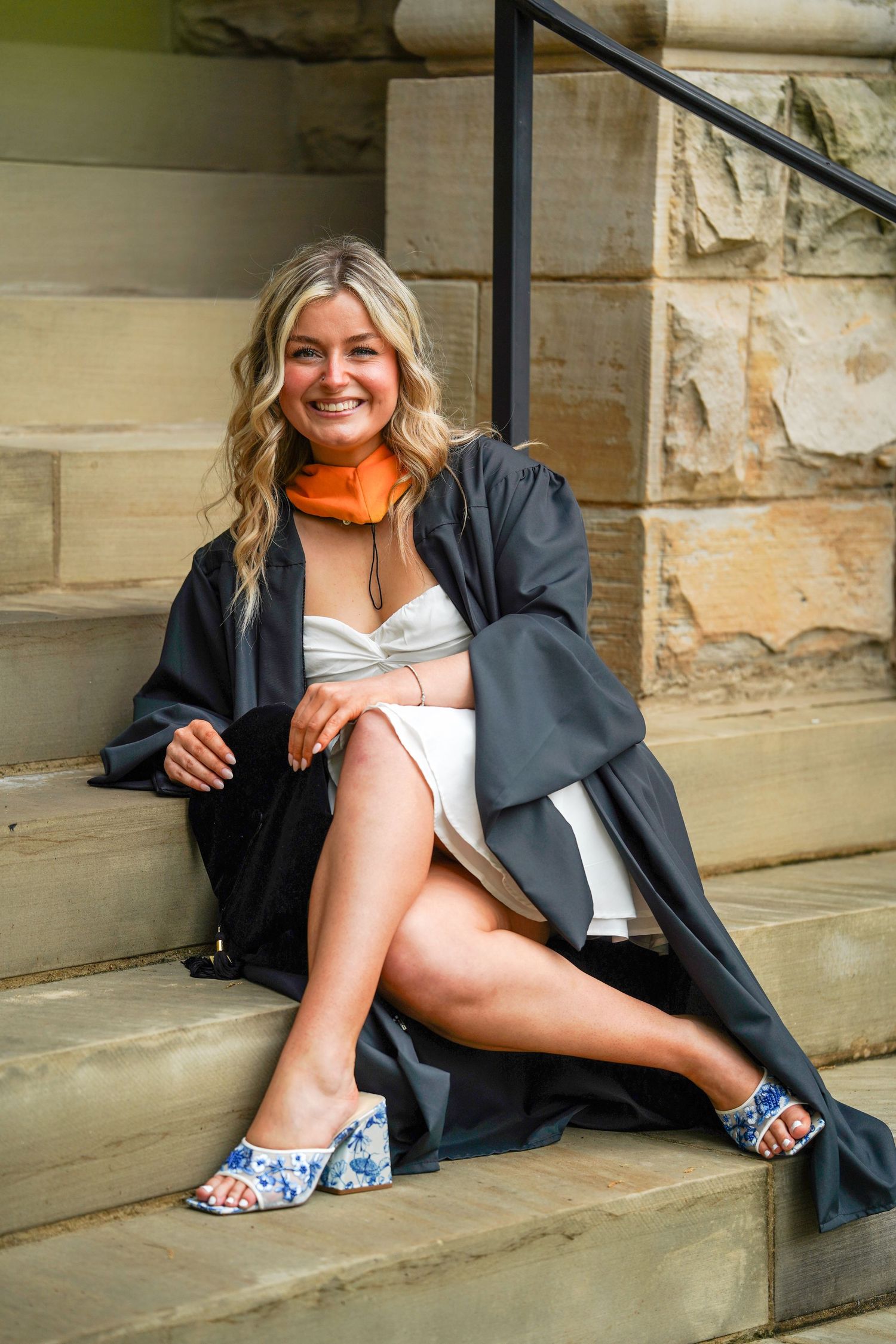 Series of artistic portraits showing someone reclining on stone steps in business attire with high heeled sandals.