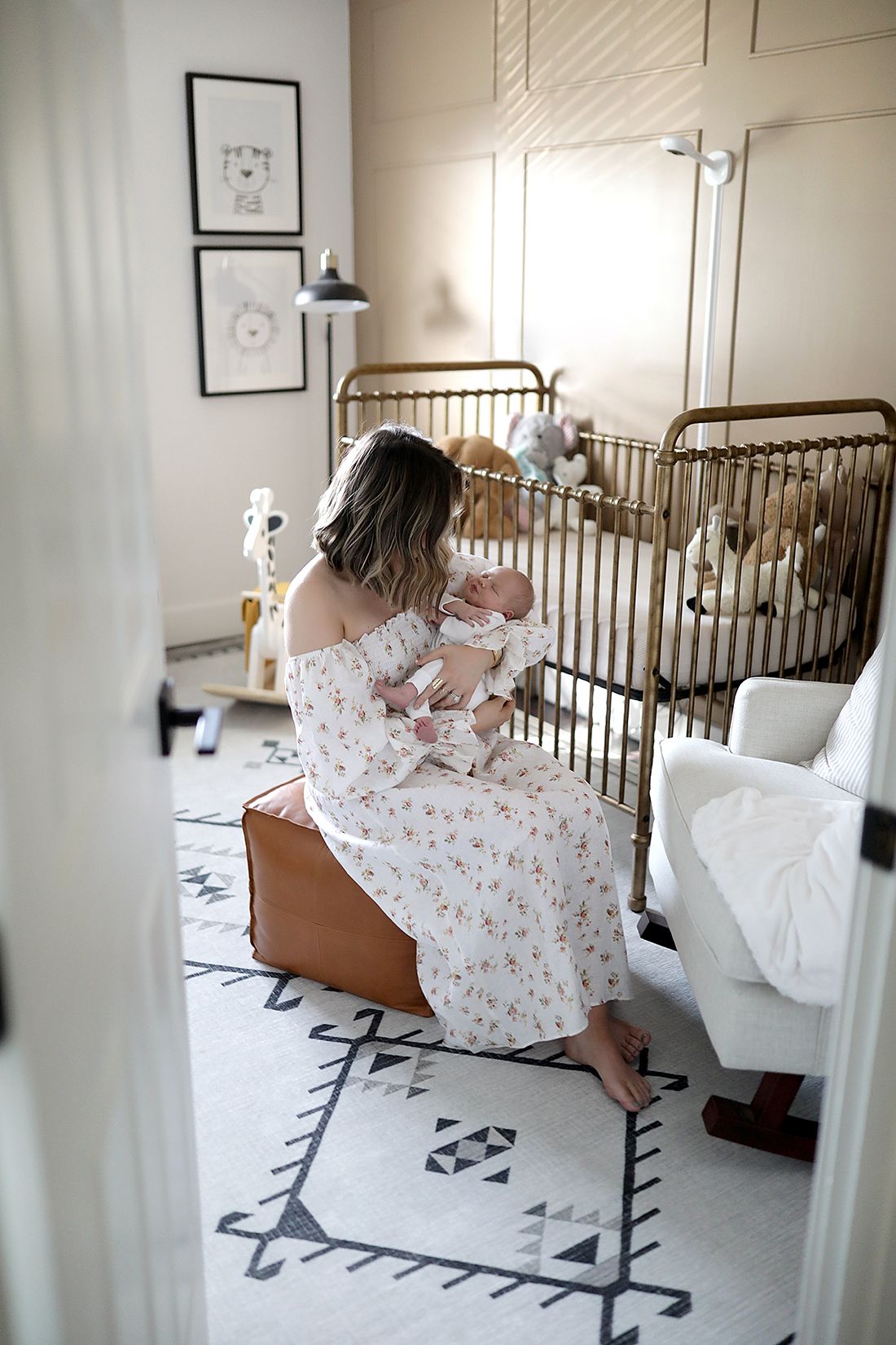 Natural light nursery with vintage metal crib and patterned area rug. Newborn photographer Medina, Ohio.