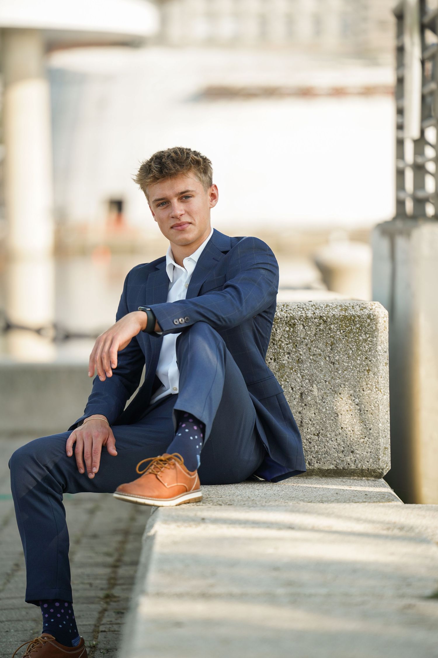 Three identical photos showing someone in a navy suit lounging on concrete steps outdoors.
