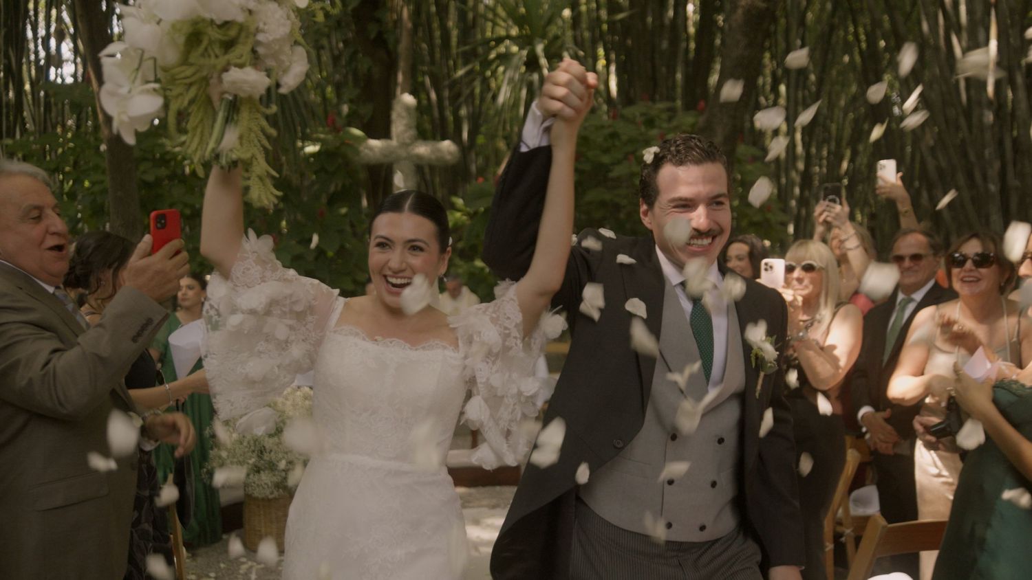 A joyful wedding celebration moment with confetti and raised hands.