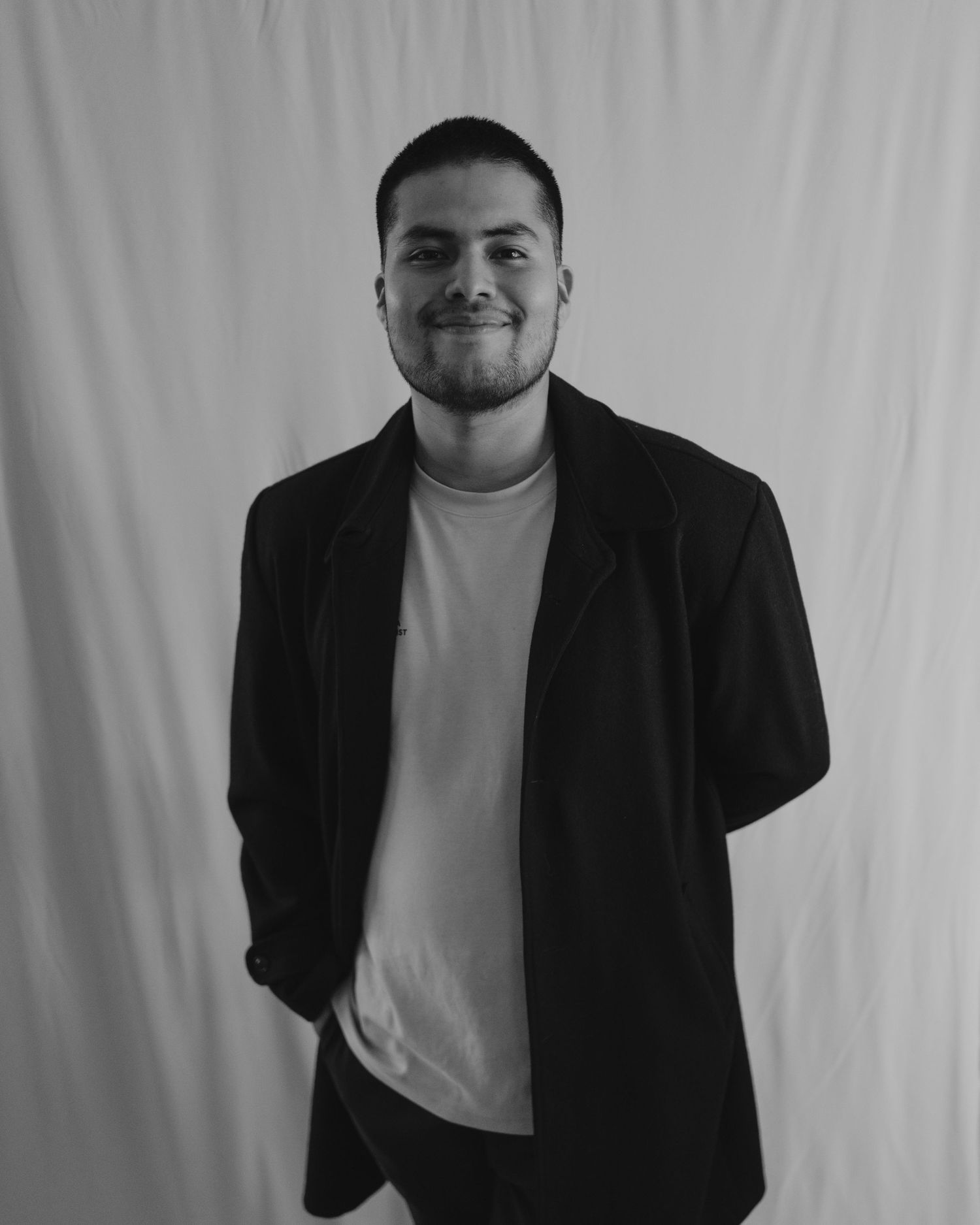 A black and white studio portrait against a plain backdrop.