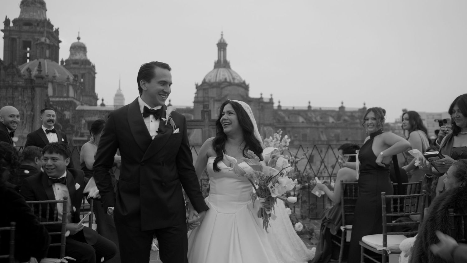 A black and white cityscape view with a couple celebrating their wedding day.