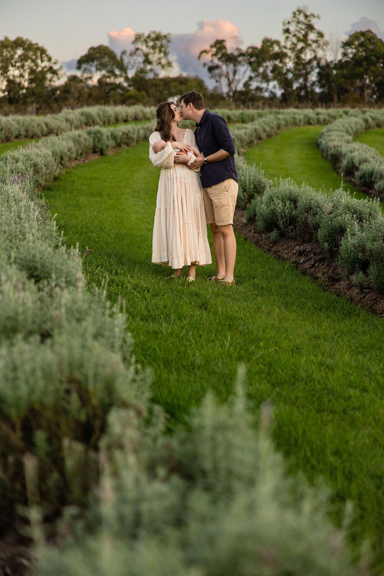 A romantic moment captured between a couple standing in lush lavender fields at sunset.
